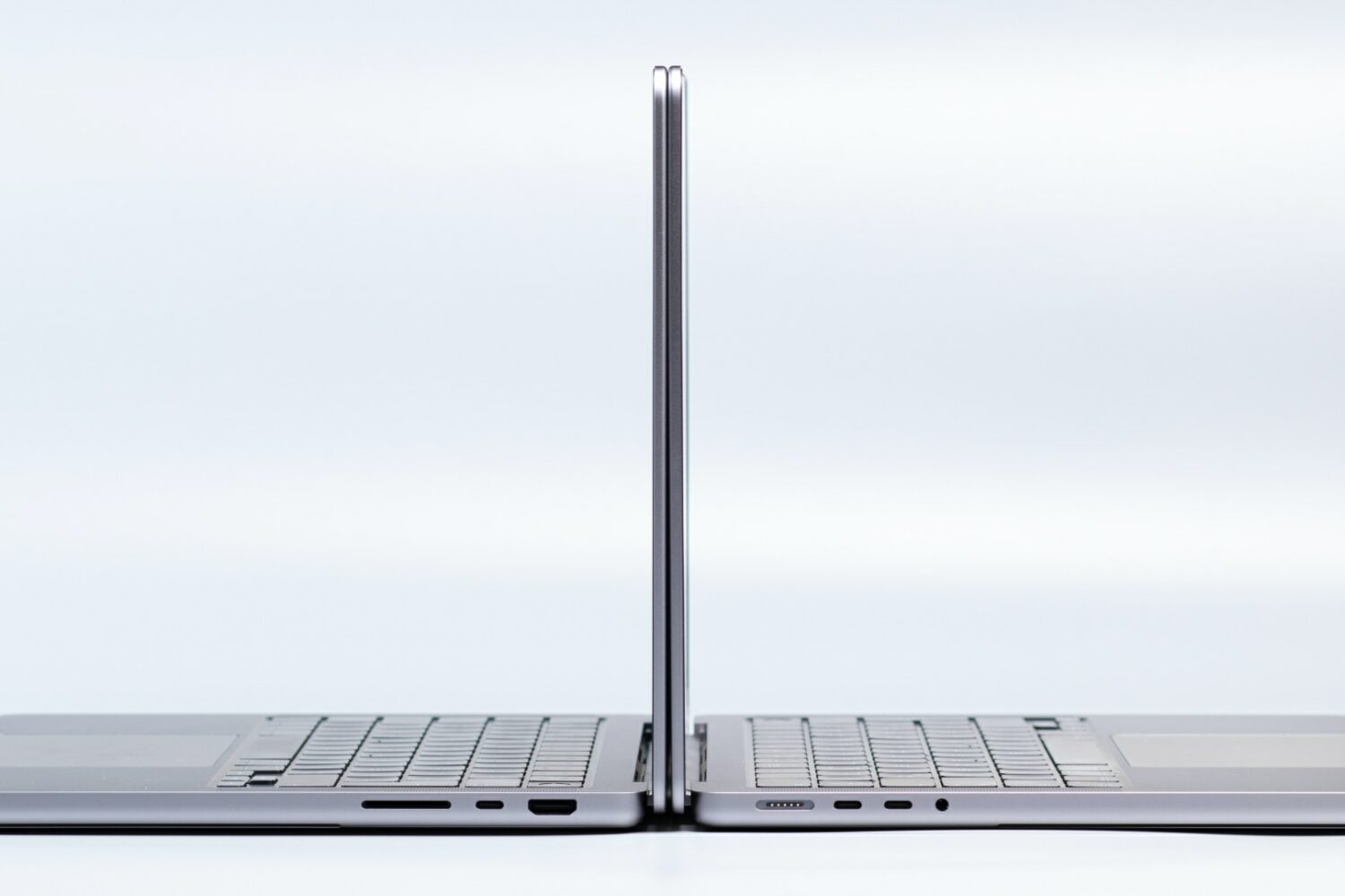 Two MacBook Pro laptops side by side, with their lids open